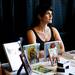 Ann Arbor resident Christine O'Conner sits at a table selling John Maggie flip books, comics, and original paintings at the last final Shadow Art Fair at the Corner Brewery in Ypsilanti on Saturday, July 20. Daniel Brenner I AnnArbor.com